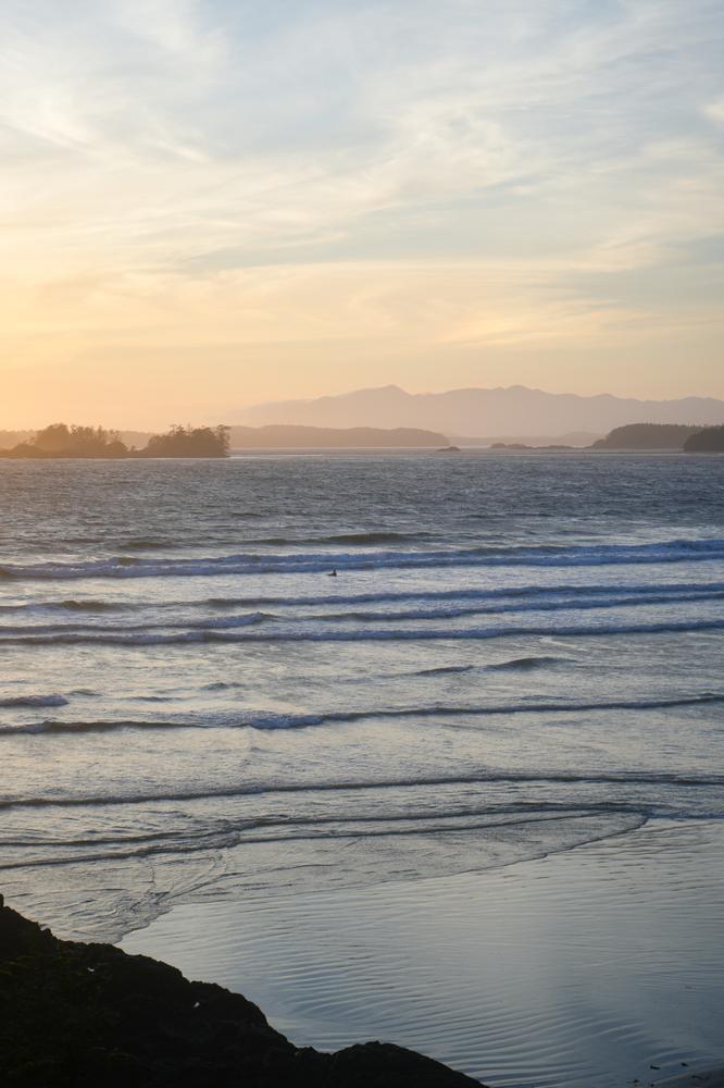 Golden sunset light over ocean and distant mountains